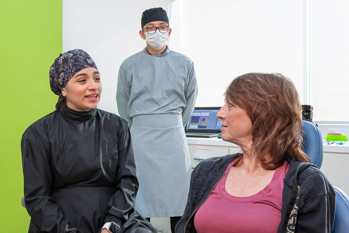 The patient and the dentist are talking about a full smile makeover in Mexico.