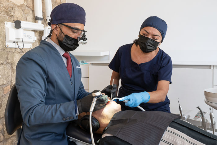 The veneer specialist is examining the patient in Mexico.